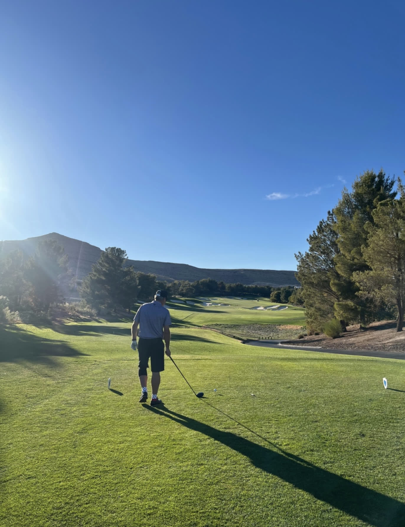 Golfer walking up the fairway at sunrise