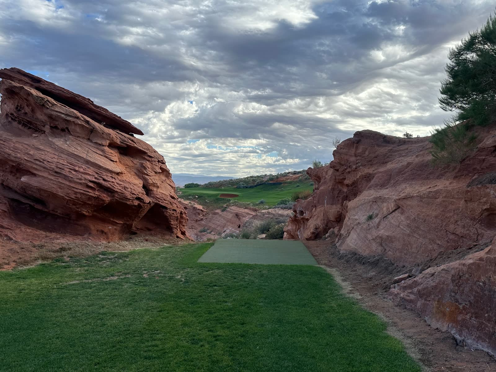 A tee box tucked between red sandstone walls at Sand Hollow